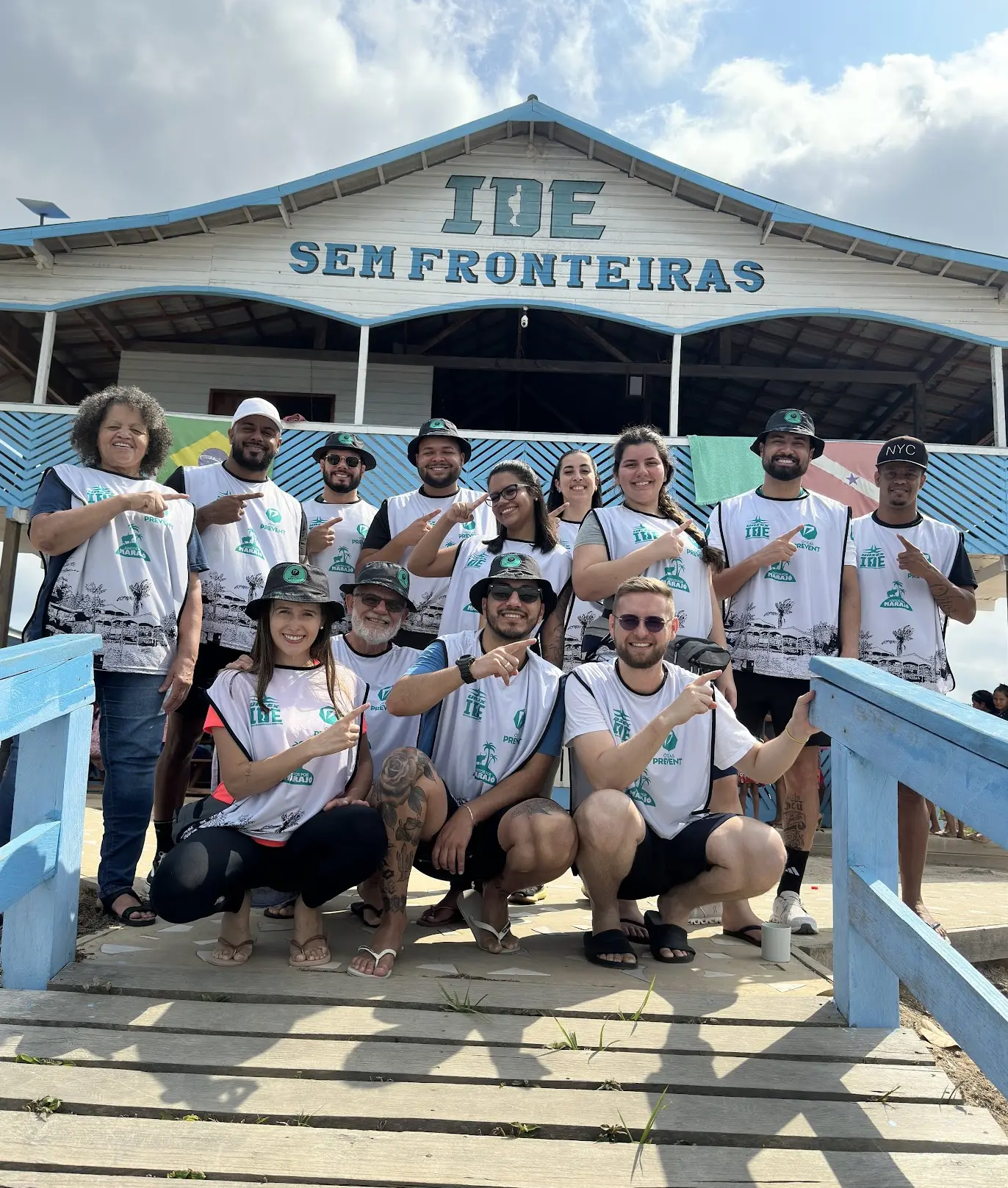 Cerca de 14 voluntários vestindo coletes da Óticas Prevent posam em frente ao prédio da ação no Marajó